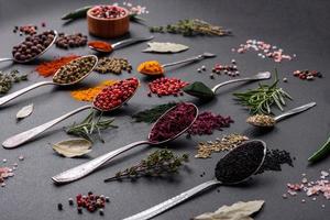 Several types of spices in metal spoons paprika, tomatoes, curry, beets, cumin, turmeric, fennel, spirulina photo