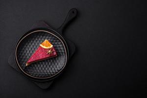 Delicious sweet cheesecake with raspberry jam on a black ceramic plate photo