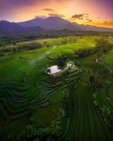 morning view in indonesia with green rice mountain at sunrise shining bright photo