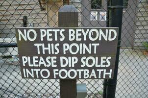 no pets beyond this point sign on fence photo