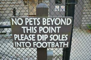 no pets beyond this point sign on fence photo