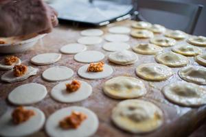 Filling and sealing puff pastry dumplings in a kitchen photo