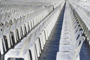 muchas sillas de plástico blancas alineadas para un espectáculo al aire libre foto