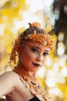 Portrait of Asian woman wearing a gold crown and gold necklace with her gorgeous make-up in black dress photo