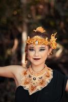 mujer balinesa con una corona de oro y un collar de oro en su maquillaje con una cara hermosa