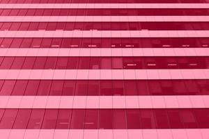 Perspective view from below on office building facade, modern skyscraper toned into Viva Magenta color. Inspired by Pantone color of the year 2023. Horizontal photo with place for text.