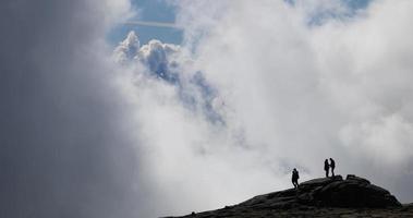 silhouettes de touristes prenant des photos et des selfies au sommet de la serra da estrela, la plus haute montagne du portugal continental. les gens au sommet de la montagne. video
