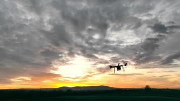 un gros plan d'un drone agro-industriel moderne sur fond de ciel coloré au coucher du soleil. video