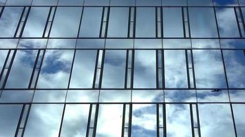 lapso de tiempo de un cielo de verano azul con nubes que se reflejan en la fachada de vidrio de un edificio de oficinas video