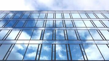 Time lapse of a blue summer sky with clouds reflecting off the glass facade of an office building video