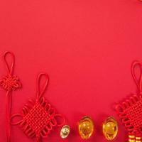 Design concept of Chinese lunar new year - Beautiful Chinese knot with plum blossom isolated on red background, flat lay, top view, overhead layout. photo