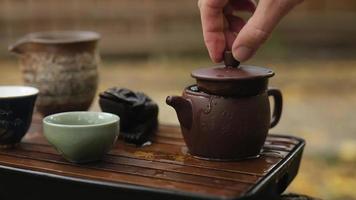 male hand closes the lid of a clay teapot video