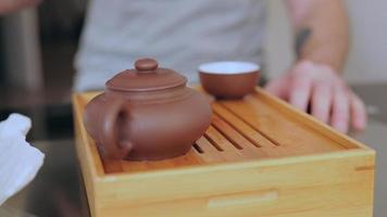 Die Hand eines Mannes gießt Tee aus einem Chahai video