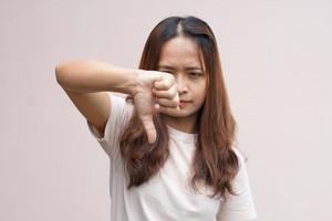 la mano de una mujer asiática levantando los pulgares como señal de disgusto foto