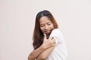 Woman scratching arm from itching on light gray background. Cause of itchy skin include insect bites Concept of health care skin. photo