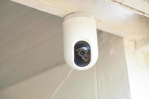 White CCTV camera on the ceiling of the house photo