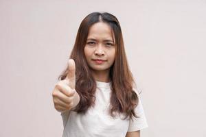 Asian woman's hand raising thumbs as a sign of greatness photo