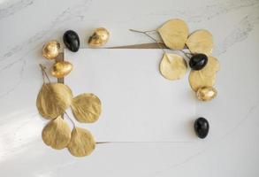 Mockup, Easter golden and black eggs with golden eucalyptus leaves. photo