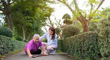 Asian senior woman fell down on lying floor because faint and limb weakness and Crying in pain form accident and her daughter came to help support. Concept of old elderly insurance and health care photo