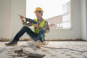 Construction worker Using an electric jackhammer to drill perforator equipment making holes before pouring the floor to be strong at construction site, Concept of worker and residential building. photo