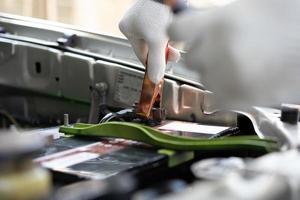 Close up and Selective focus of car mechanic holding battery electricity cables jumper for charging car battery, Services car engine machine concept photo