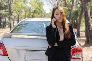 Woman drivers call insurance after a car accident before taking pictures and sending insurance. Online car accident insurance claim idea after submitting photos and evidence to an insurance company.