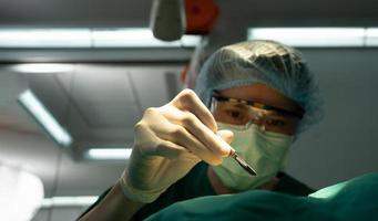 Asian Professional surgeons team performing surgery in the operating room, surgeon, Assistants, and Nurses Performing Surgery on a Patient, health care cancer and disease treatment concept photo