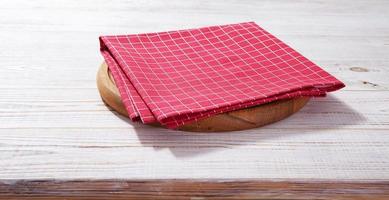 tabla de pizza vacía y servilleta roja en madera blanca foto