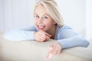 Active beautiful middle-aged woman smiling friendly and looking in camera. Woman's face closeup. Realistic images without retouching with their own imperfections. Selective focus. photo