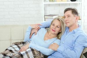 pareja en casa en el sofá hablando y sonriendo foto