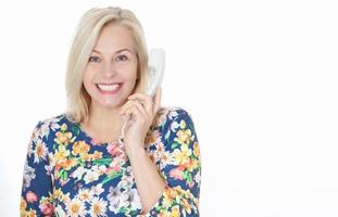 Woman in blue dress emotionally speaks on the phone isolated on white background photo