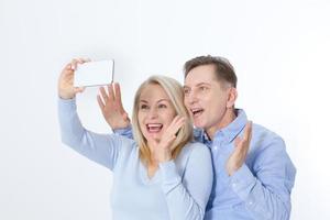 feliz pareja tomando selfie con smartphone aislado en blanco foto