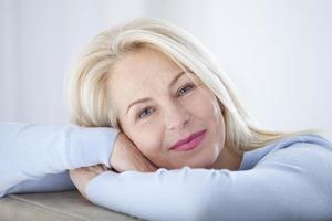 activa hermosa mujer de mediana edad sonriendo amable y mirando a la cámara. primer plano de la cara de la mujer. imágenes realistas sin retoques con sus propias imperfecciones. enfoque selectivo. foto