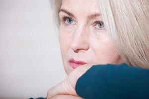 Sad woman sitting on a sofa in the living room photo