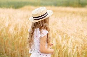chica en un campo de trigo. chica con sombrero. niño en el pueblo. foto