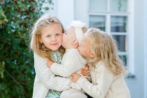 3 niñas de pelo claro se abrazan. amor de hermanas. Las chicas del clima se quieren mucho. conexión de enfermería. cálidas relaciones en la familia. foto tierna de tres niñas pequeñas