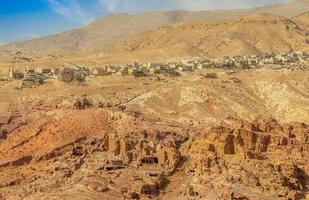 View to the ancient Nabataean Moghar Annasara tombs with Wadi Musa town in the background, Petra, Jordan