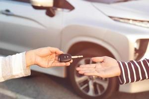 intercambio de empresarios entregando las llaves del auto a una mujer joven. foto