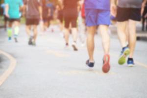 grupo de fotos borrosas multitud de personas. Pies de corredor de atleta haciendo ejercicio en la pista de carreras en la calle cerca de la orilla en el parque público. concepto de bienestar de entrenamiento de trote de fitness.