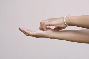 Woman scratching arm from itching on light gray background. Cause of itchy skin include insect bites Concept of health care skin. photo