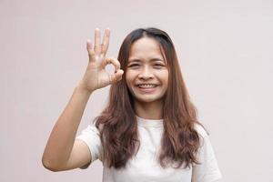 mujer asiática haciendo el signo de la mano ok foto