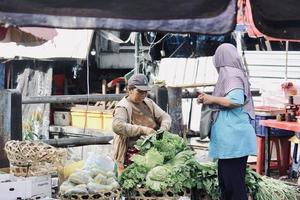 Badung Bali January 13 2023 A buyer is seen buying fresh fruit and vegetables at a traditional market in Bali photo