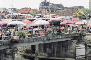 Photo of several people doing buying and selling activities in the Kumbasari market area.