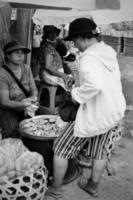 Badung, Bali - January 13 2023 Black and White Photo of a seller transacting with a buyer at the Badung Kumbasari Market