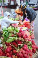 Badung Bali January 13 2023 A buyer is seen buying fresh fruit and vegetables at a traditional market in Bali photo