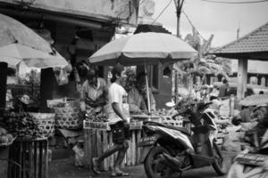 badung, bali - 13 de enero de 2023 foto en blanco y negro de un vendedor que realiza transacciones con un comprador en el mercado de badung kumbasari