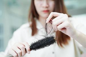 las mujeres asiáticas tienen problemas con la pérdida de cabello largo y se adhieren al cepillo de peine. foto