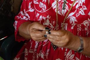 hands crafting Polynesia shell necklage photo
