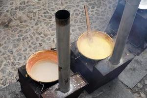 rango, italia - 8 de diciembre de 2017 - gente cocinando polenta harina tradicional de maíz y trigo foto