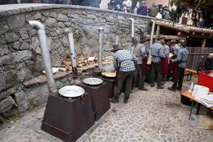 RANGO, ITALY - DECEMBER 8, 2017 - People cooking polenta traditional corn wheat meal photo